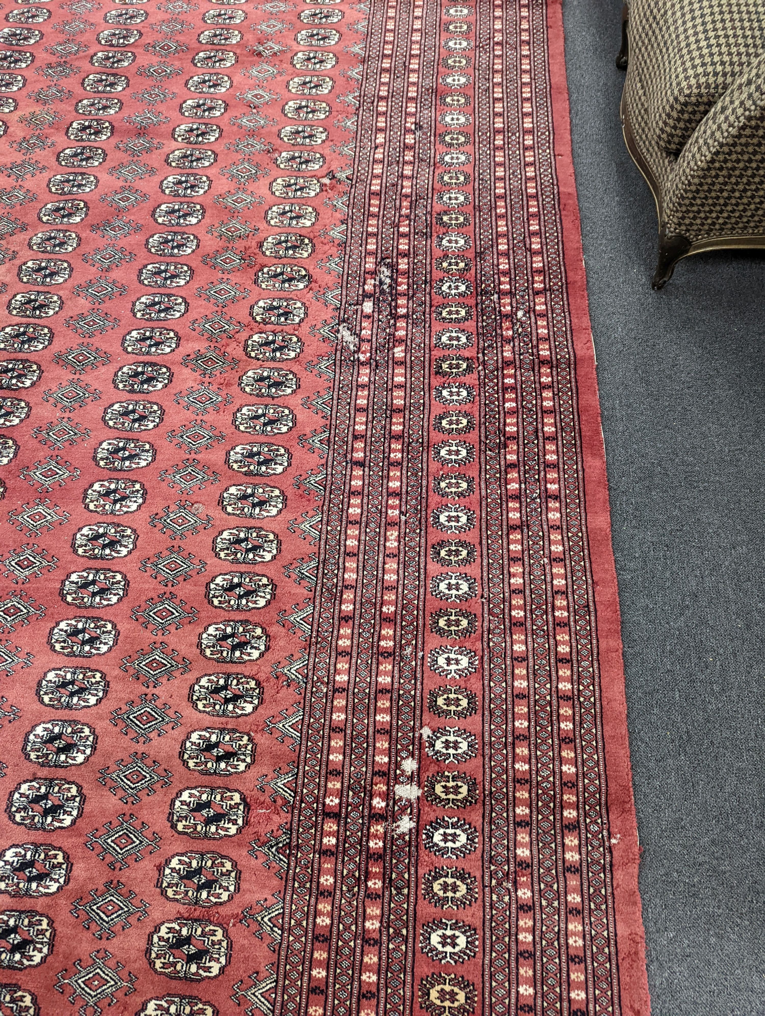 A Bokhara burgundy ground carpet, 360 x 276cm